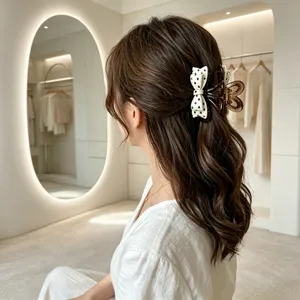 Close-up detail of a Korean style bow hair claw clip featuring chic polka dot pattern.