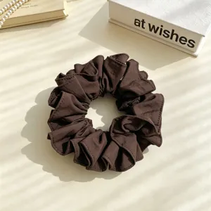 Dark brown fabric hair scrunchie detail view, elegant ruffled design for daily hairstyles.