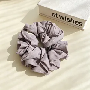 Purple fabric hair scrunchie with elegant contrast white stitching for women daily wear.