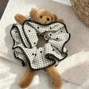Cute plush bear hair scrunchie with brown plaid pattern and ruffle edge for women daily styling.