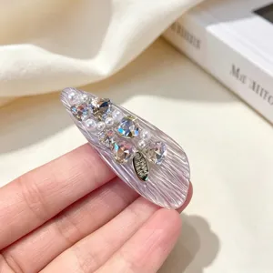 Detailed view of a trendy Korean style side hair clip decorated with shining rhinestones and pearls.