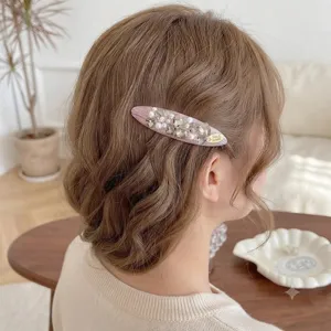 Close-up view of exquisite pink pearl rhinestone hair clip, elegant side hair accessory detail.