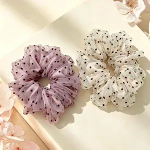 Close-up detail of Korean style polka dot mesh scrunchie, soft organza hair accessory.