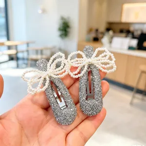 Detail close-up of Korean style sparkling silver rhinestone pearl bow hair clips.