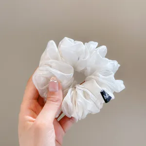White translucent organza hair scrunchie, fluffy pleated design for elegant styling.