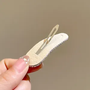 Detail view of the sparkling rhinestone snap hair clip back structure, premium metal and velvet backing.