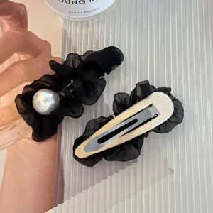 Detail view of Korean black mesh hair clip with faux pearl and metal snap pin design.