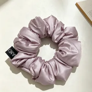 Élégant chouchou en satin mauve pour femme, accessoire de coiffure plissé et attache queue de cheval.