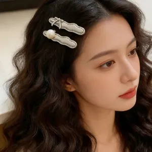 Elegant metallic hair clips featuring a delicate bow and pearl design for stylish daily use.