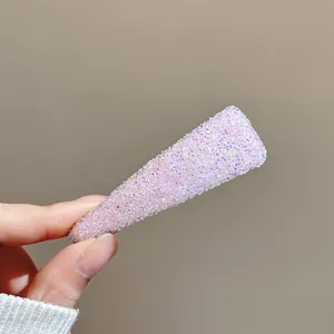 Gros plan détail d'une barrette à cheveux rose étincelante avec texture et attache.