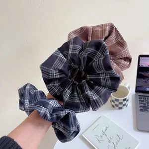 Plaid hair scrunchies detail view, soft fabric hair tie, retro style ponytail holder accessory.