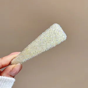 Gros plan détail de la pince à cheveux en cristal scintillant, bel accessorio strassé.