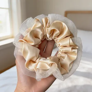 Gros-plan sur l'élégant chouchou en satin champagne et dentelle fine et délicate.