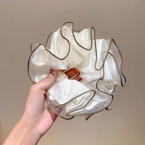 Detailed view of white shimmering lace oversized hair scrunchie, soft and stylish hair tie.