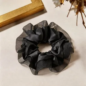 Détail chouchou cheveux en satin et dentelle, attache noire élégante, accessoire doux.