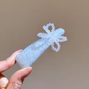Close-up detail of light blue sparkly crystal hair clip with cute beaded bow design.