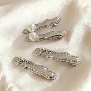 Silver metal hair clips detailed with classic bows and elegant pearls for daily stylish wear.