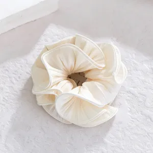 Close-up detail of white ruffled hair scrunchie, soft pleated texture for elegant gentle hairstyles.
