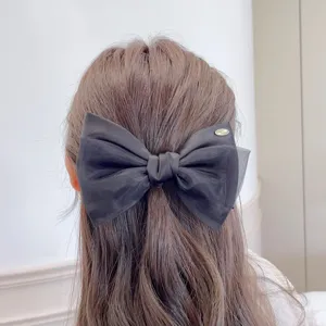 Detail shot of black organza double-layer bow hair clip showing exquisite texture and neat styling.