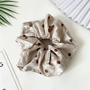 Chouchou en satin à pois élégant, accessoire de coiffure minimaliste pour le quotidien.