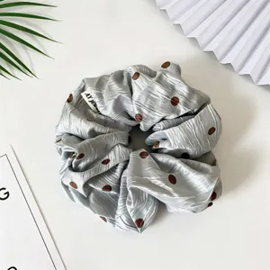 Chouchou en satin gris à pois vue de détail, accessoire de cheveux élégant pour femmes.
