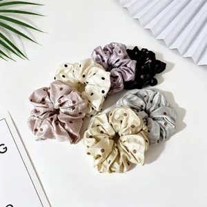 Vue détaillée de chouchous en satin à pois multicolores montrant leur texture douce.