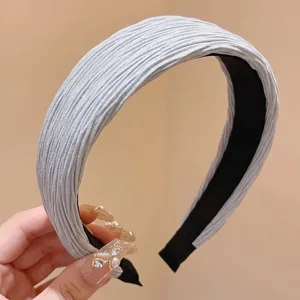 Close-up view of the elegant pleated grey headband, showing soft fabric texture and inner lining.