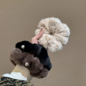 Vista dettagliata di scrunchies in peluche con decorazioni di perle, consistenza morbida ed elastica.