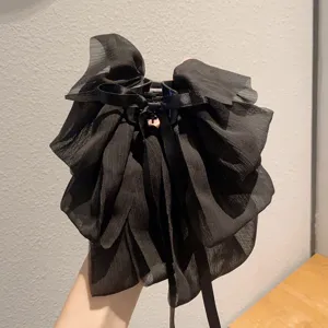 Black chiffon bow hair claw detail, elegant cascading ribbon design for hairstyles.