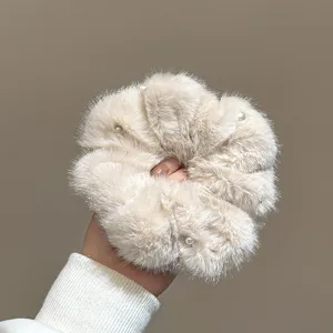 Vista dettagliata di un elastico per capelli in peluche soffice con perle, morbido ed elegante.