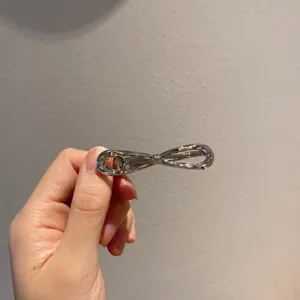 Zilveren metalen strik haarspeld detailweergave, elegante haaraccessoire voor dagelijks gebruik.