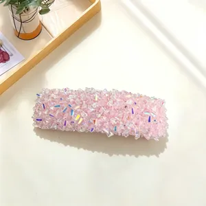 Detail of pink crystal hair clip, sparkling rhinestone surface texture close-up shot
