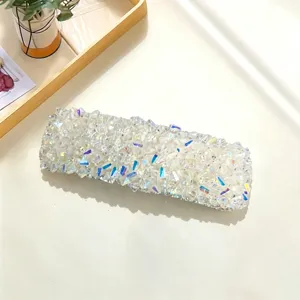 Detailed close-up of glittering crystal rhinestone hair clip, showing sparkling diamond texture.