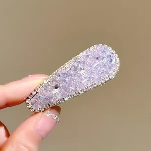 Close-up detail shot of a sparkling purple crystal rhinestone hair clip, elegant and shiny.