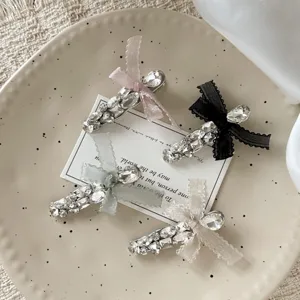Close-up detail of sparkling rhinestone hair clips with delicate bow knots for cute hairstyles.