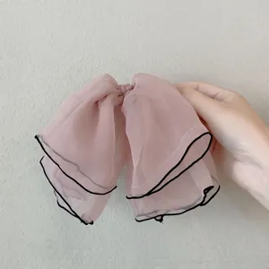 Chiffon bow hair clip for women, elegant summer pink hair accessory with black trim.