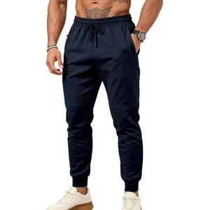 Vista dettagliata pantaloni tuta uomo con polsino, cordino regolabile e tasche con zip sicure.