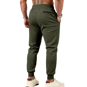 Dettaglio vista posteriore pantaloni tuta verde oliva da uomo con tasche con zip.