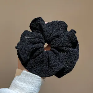 Vista dettagliata dell'elastico per capelli in maglia nera, accessorio fatto a mano stile.