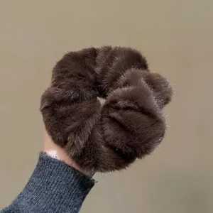 Gros plan détaillé d'un chouchou en peluche marron foncé, texture douce et bande élastique solide.