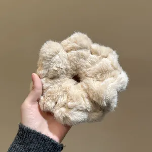 Chouchou en fausse fourrure duveteuse en gros plan, accessoire pour cheveux kaki doux.