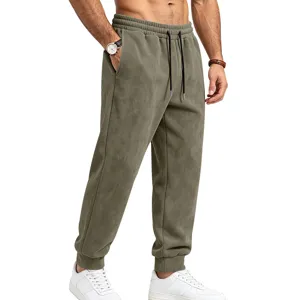 Close-up detail of men's olive green suede sweatpants with drawstring and elastic waist.