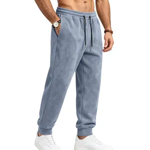 Detail view of men's greyish-blue suede sweatpants featuring an elastic drawstring waist.