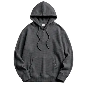 Detail view of dark gray waffle knit fabric texture, half-zip collar and drawstring hoodie.