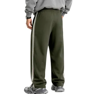 Detail view of men's fleece-lined side-stripe baggy sweatpants in dark green knit.