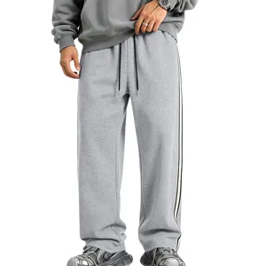 Close-up detail of grey fleece wide leg sweatpants featuring side stripes and drawstring.