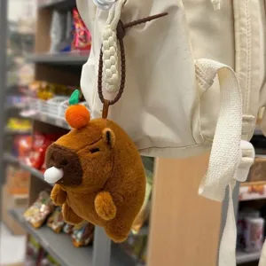 Joli pendentif en peluche capybara accroché au sac à dos, détail doux et duveteux en magasin.
