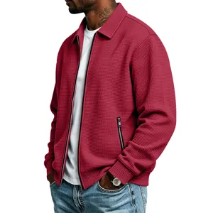 Detail close-up van rode heren wafelgebreide jas met ritszakken voor casual stijl.