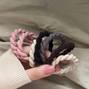 Close-up detail of multi-color braided hair ties showing textured rope design and elasticity.