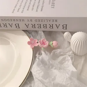 Close-up detail of the sweet pink flower hair clip, featuring delicate floral and bud design.
